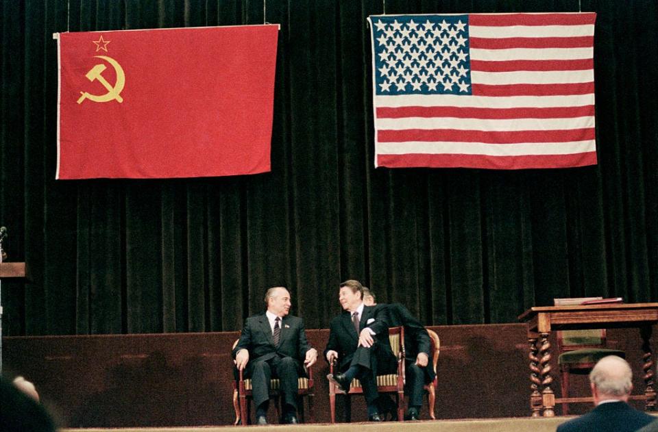 At center stage, both at the International Press Center and in the world scheme of things, Soviet leader Mikhail Gorbachev and U.S. president Ronald Reagan smile during concluding summit ceremony.