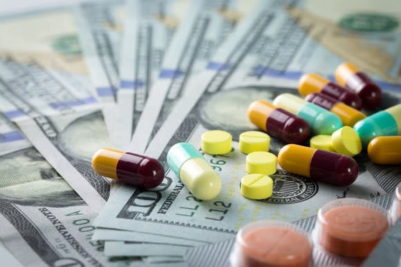 Prescription drugs on a bed of hundred-dollar bills.