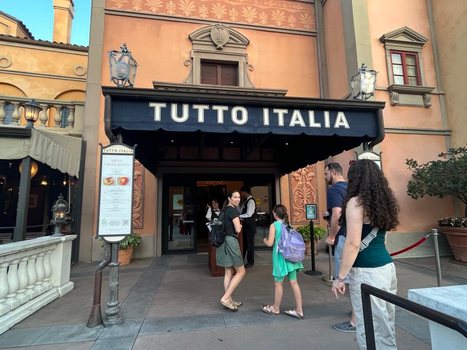 outside of tutto italia, black awning with orange building behind it