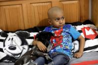 Hermes Soto embraces Wicha the dog as he watches a movie at his house in Mexico City