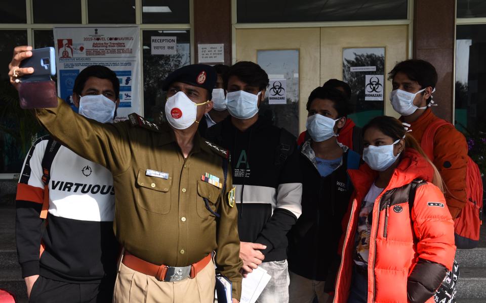 A policeman clicks slefie with Indians who were air-lifted from Wuhan following the outbreak of the deadly cornavirus.