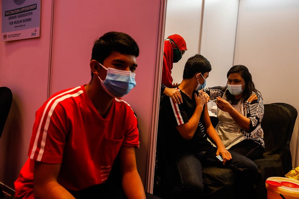 Twins Danial Husni (left) and Danish Husni, 16, receive their Covid-19 vaccination at the Subterranean Penang International Convention and Exhibition centre in Bayan Baru September 22, 2021. — Picture by Sayuti Zainudin