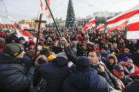 Protesters argue with pro-government people dressed in black during a rally in downtown Minsk, Belarus, Saturday, Dec. 7, 2019. Several hundreds demonstrators gathered to protest against closer integration with Russia. (AP Photo/Sergei Grits)