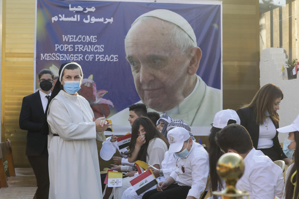 Faithful wait outside the Chaldean Cathedral of Saint Joseph where Pope Francis is expected to concelebrate mass in, in Baghdad, Iraq, Saturday, March 6, 2021. Earlier today Francis met privately with the country's revered Shiite leader, Grand Ayatollah Ali al-Sistani. (AP Photo/Andrew Medichini)