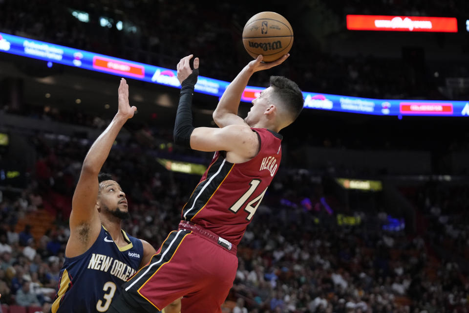 Miami Heat guard Tyler Herro (14) goes up for a shot against New Orleans Pelicans guard CJ McCollum (3) during the first half of an NBA basketball game, Sunday, Jan. 22, 2023, in Miami. (AP Photo/Wilfredo Lee)