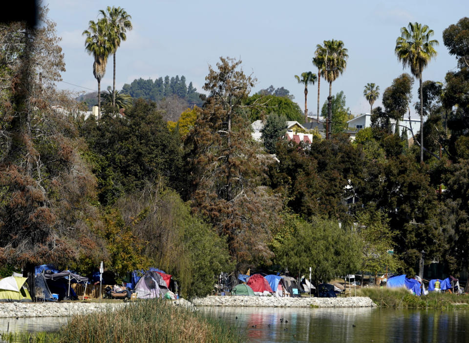 FILE - In this March 26, 2021, file photo, a homeless encampment is seen around the west perimeter of Echo Park Lake. Los Angeles City Council is poised to clamp down on homeless encampments, making it illegal to pitch tents on some sidewalks, beneath overpasses and near parks. The measure being considered Thursday, July 1, 2021, is billed as a humane way to get people off streets and restore access to public spaces. (AP Photo/Damian Dovarganes, File)