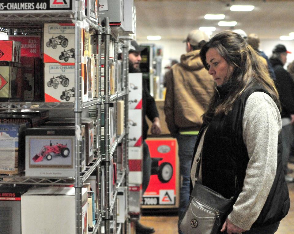 Lori Steiner looks at Allis-Chalmers farm toys during the 33rd annual Ashland FFA Alumni Farm Toy show Sunday, Dec. 18, 2022 in Mozelle Hall at the Ashland County Fairgrounds. Steiner, of Killbuck, was Christmas shopping with husband Vern.