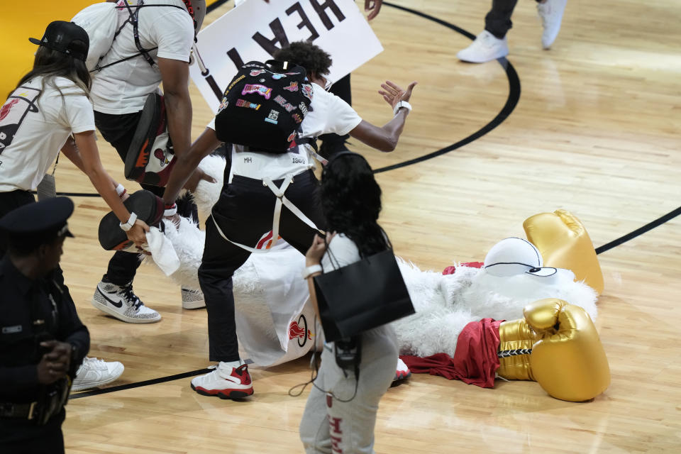 Burnie, the Miami Heat mascot, is dragged off the floor after he was punched by former UFC champion Conor McGregor during a break in Game 4 of the basketball NBA Finals against the Denver Nuggets, Friday, June 9, 2023, in Miami. The man who occupies Burnie's costume needed medical attention. (AP Photo/Lynne Sladky)