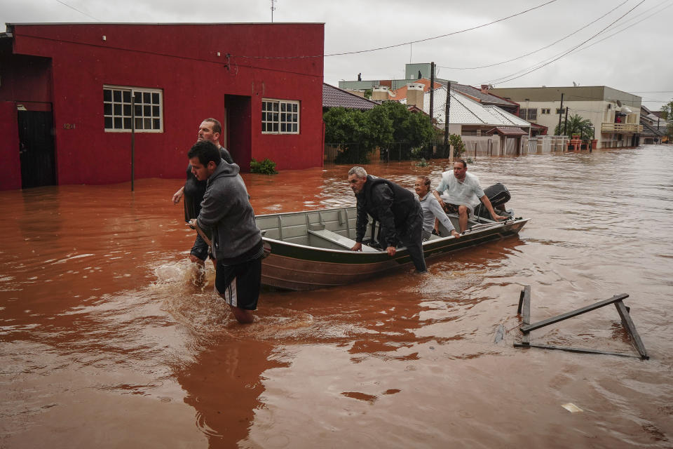 People evacuate a flooded area after heavy rain in Sao Sebastiao do Cai, Rio Grande do Sul state, Brazil, Thursday, May 2, 2024. (AP Photo/Carlos Macedo)