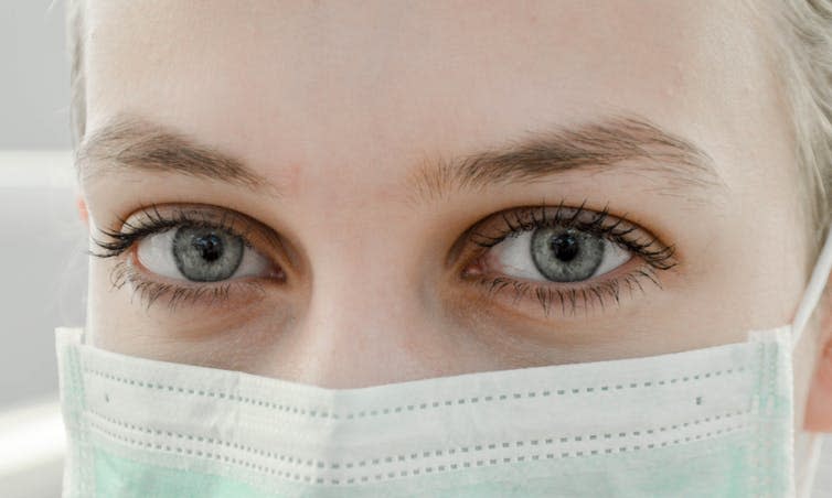 Close-up photo of woman's eyes above surgical mask.