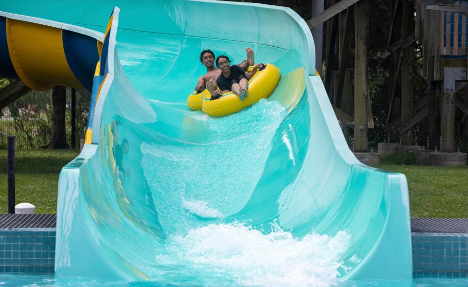 Mahi Rahman, left, and Fahmida Meem ride a plastic tube down a giant slide at the Wayne County Family Aquatic Center in Detroit on Friday, July 21, 2023.
