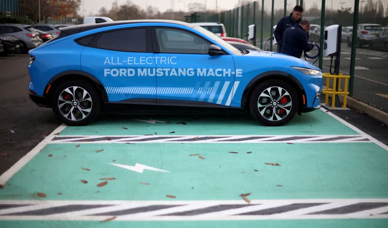 FILE PHOTO: Workers plug in an electric Ford Mustang Mach-e electric vehicle during a press event at the Ford Halewood transmissions plant in Liverpool