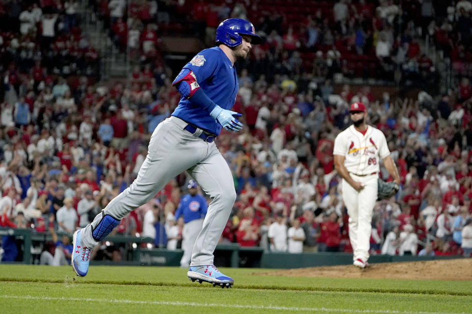 Chicago Cubs' Ian Happ, left, rounds the bases after hitting a two-run home run off St. Louis Cardinals relief pitcher Luis Garcia, right, during the ninth inning of a baseball game Saturday, Oct. 2, 2021, in St. Louis. (AP Photo/Jeff Roberson)