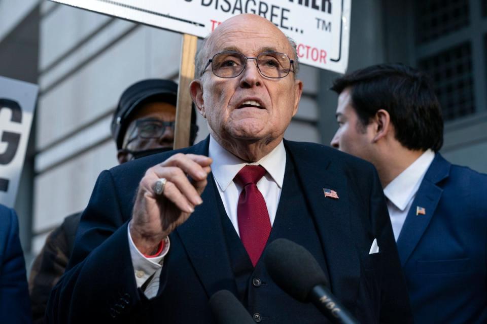 Former mayor of New York Rudy Giuliani speaks during a news conference outside the federal courthouse in Washington on 15 December 2023 (AP)