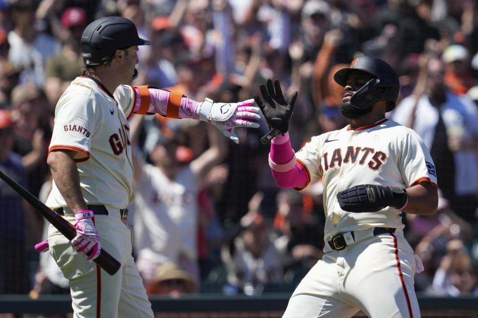 San Francisco Giants' Heliot Ramos, right, celebrates with Casey Schmitt, left, after scoring against the Cincinnati Reds during the fifth inning of a baseball game Sunday, May 12, 2024, in San Francisco. (AP Photo/Godofredo A. Vásquez)