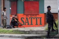 A combat police sniper (L) takes position during an encounter with rebels from the Moro National Liberation Front (MNLF) in downtown Zamboanga City, southern Philippines September 9, 2013. The rebels took 30 civilian hostages in the southern Philippines on Monday and held security forces in a standoff as part of a drive to derail peace talks, officials said. Police commandos cordoned off parts of Zamboanga City on the island of Mindanao after a rogue faction of the Moro National Liberation Front (MNLF) took hostages and tried to march to the city hall to raise their flag, an army commander said. REUTERS/STRINGER (PHILIPPINES - Tags: POLITICS MILITARY CIVIL UNREST)