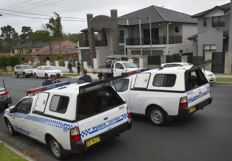 Police stand guard outside a house as four people are arrested over the terror-linked murder of a police employee after coordinated raids by more than 200 officers on properties across Sydney on October 7, 2015