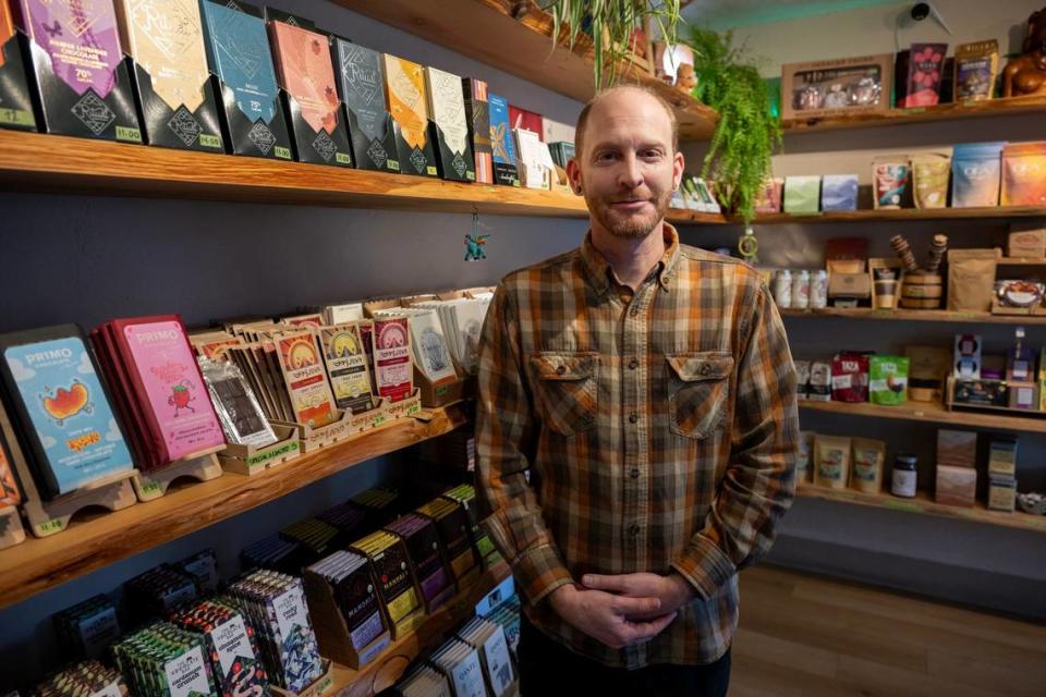 Owner Ariel Wolansky stands on Jan. 18, 2024, with the various chocolate and cacao products he sells at Cafe Xocolatl in downtown Sacramento. Paul Kitagaki Jr./pkitagaki@sacbee.com