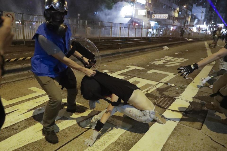 港警粗暴對待女性的影像和證言屢屢見諸媒體。圖為香港一○二一遊行中，港警幾乎扯掉一名女性抗爭者的上衣，露出內衣。（達志影像）