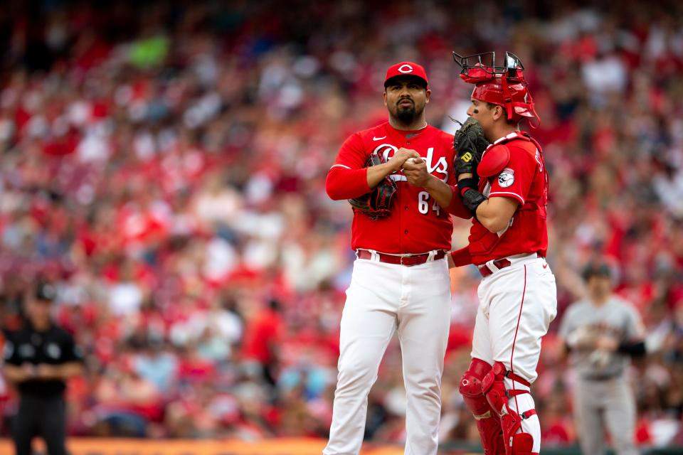 Cincinnati Reds starting pitcher Tony Santillan (64) speaks with Cincinnati Reds catcher Tyler Stephenson in the ninth inning of the MLB game between the Cincinnati Reds and the San Francisco Giants at Great American Ball Park in Cincinnati, Saturday, May 28, 2022.