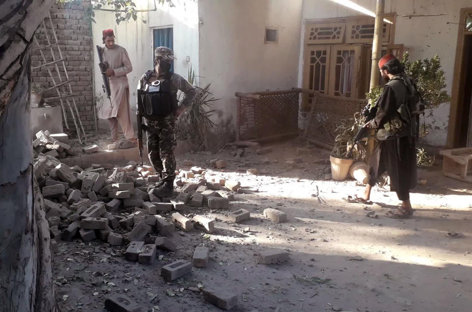 Taliban fighters inspect at the site roadside bombing in Jalalabad east of Kabul, Afghanistan, Saturday, Oct. 23, 2021. A roadside bombing targeting a Taliban vehicle in eastern Afghanistan killed at least two civilians Saturday, including a child, Taliban and health officials said. Four others were wounded. (AP Photo/Shir Shah Hamdard)