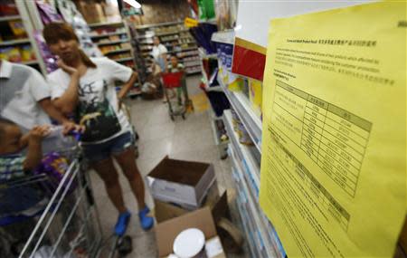 A woman looks at a notice about the product recall of some of Dumex and Abbott's milk powder products at a supermarket in Beijing in this August 7, 2013 file photo. REUTERS/Kim Kyung-Hoon/Files