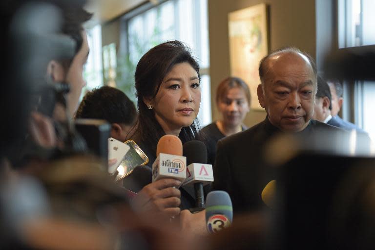 Ousted Thai Prime Minister Yingluck Shinawatra (C) answers reporters' questions in Bangkok on March 25, 2015