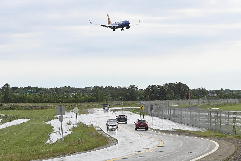 A plane flys over flooding on I-94 eastbound service drive at Vinning Road on Thursday, Aug. 24, 2023, Romulus, Mich. Officials say parts of southeast Michigan got over 5 inches of rain by Thursday morning resulting in street flooding in the Detroit area, including tunnels leading to Detroit Metropolitan Airport. (Clarence Tabb Jr./Detroit News via AP)