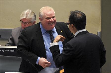 Toronto Mayor Rob Ford (C) speaks with Councillor Denzil Minnan-Wong during a city council meeting in Toronto November 15, 2013. REUTERS/Jon Blacker