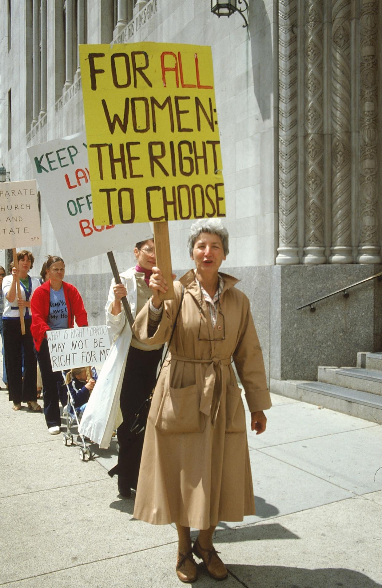 Pro-choice advocates holding signs, picketing for legalized abortions.