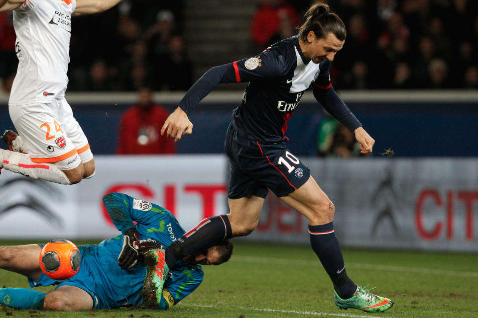 Paris Saint Germain's Zlatan Ibrahimovici, right, challenges for the ball with Valencienne's Nicolas Penneteau, bottom, during their French League one soccer match, at the Parc des Princes stadium, in Paris, Friday, Feb. 14, 2014. (AP Photo/Thibault Camus)