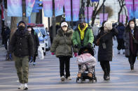 People walk in frigid temperatures along the street in in Seoul, South Korea, Wednesday, Jan. 25, 2023. Thousands of travelers swarmed a small airport in South Korea's Jeju island on Wednesday in a scramble to get on flights following delays by snowstorms as frigid winter weather gripped East Asia for the second straight day. (AP Photo/Ahn Young-joon)
