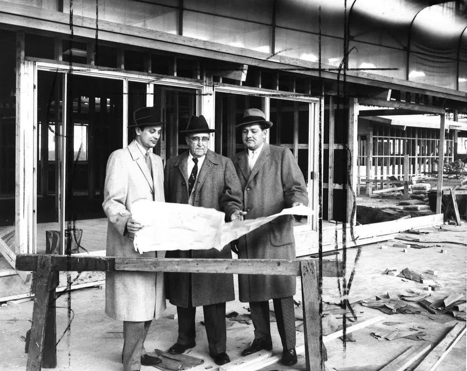 Managing Director of the Indianapolis Home Show J. Frank Cantwell , center, views plans of the centerpiece home while it is being constructed on April 7, 1957.