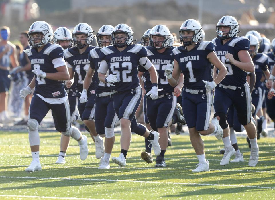 Garrett Miller (52) and his Fairless Falcons teammates take the field before an Aug. 19, 2021 high school football game against Sandy Valley at Fairless.