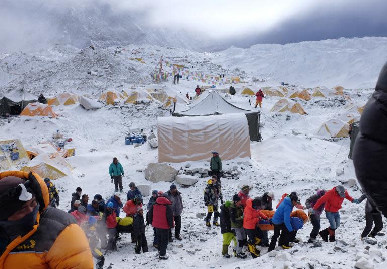 Rescuers use stretchers to carry the injured at Everest Base Camp, after an earthquake triggered avalanche crashed through parts of the base camp killing 18 people, April 26, 2015