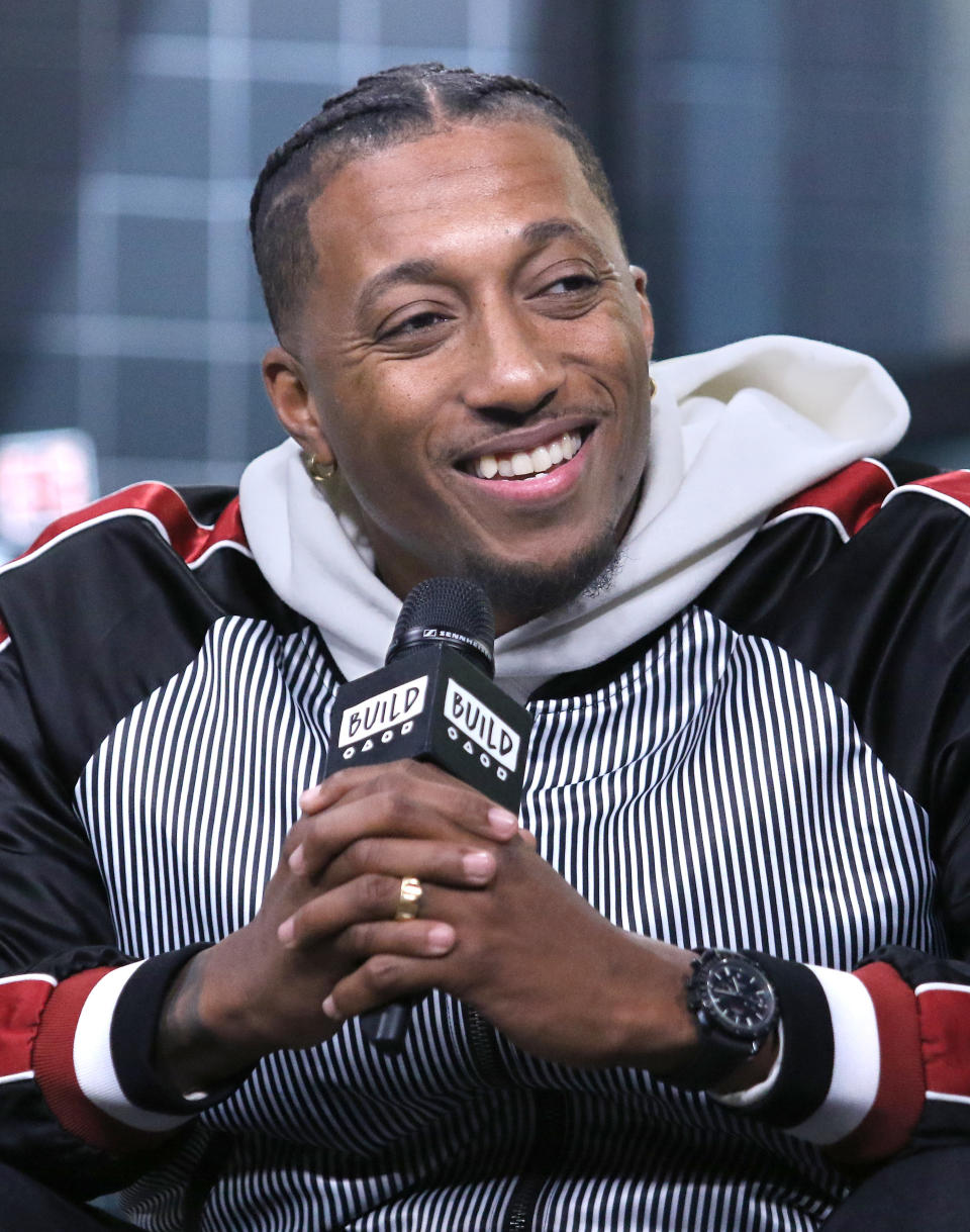 Lecrae holding a mic.