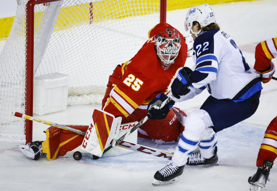 Winnipeg Jets forward Mason Appleton, right, has his shot blocked Calgary Flames goalie Jacob Markstrom during the second period of an NHL hockey game Saturday, Nov. 12, 2022, in Calgary, Alberta. (Jeff McIntosh/The Canadian Press via AP)