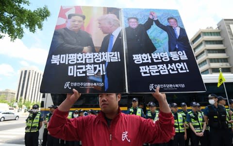 Protests, however, were held in South Korea where president Moon Jae-in watched on hopefully - Credit:  JUNG YEON-JE/AFP