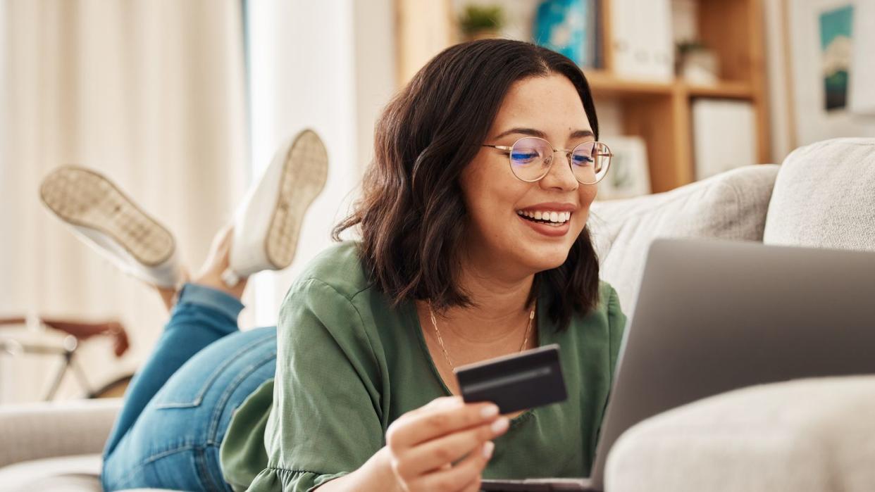 woman shopping online with credit card in hand