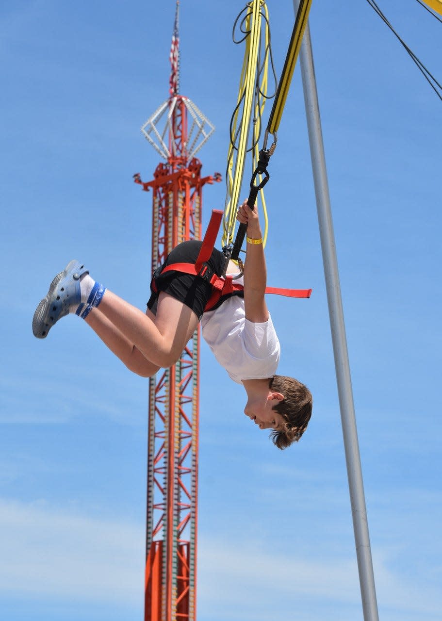 A boy spins on the Bungee Jump, one of the popular rides at the fair.