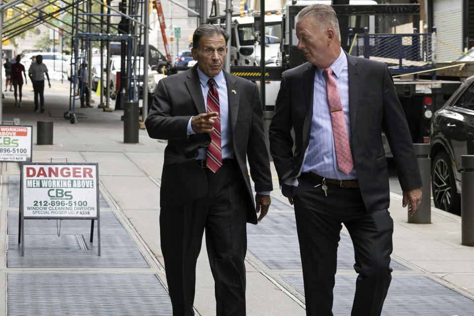 In this July. 27, 2022 photo, retired NYPD detective Louis Scarcella, left, walks towards Kings County Supreme Court, in the Brooklyn borough of New York. In the past nine years, nearly 20 murder and other convictions have been tossed out after defendants accused Scarcella of coercing or inducing false confessions and bogus witness identifications, which he denies. (AP Photo/Yuki Iwamura)