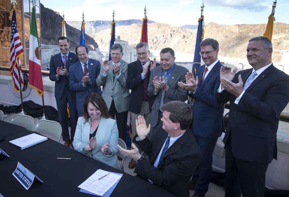 Brenda Burman seated, then the commissioner of the Bureau of Reclamation, applauds after the signing of the Colorado River Drought Contingency Plan, May 20, 2019, at Hoover Dam. Looking on are representatives the from seven Colorado River Basin states, who also signed the plan.