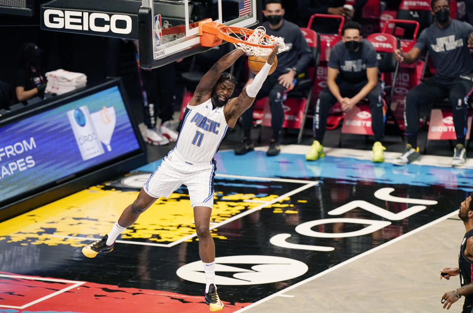 Orlando Magic forward James Ennis III (11) hangs from the rim after dunking unopposed during the first quarter of an NBA basketball game against the Brooklyn Nets, Thursday, Feb. 25, 2021, in New York. (AP Photo/Kathy Willens)