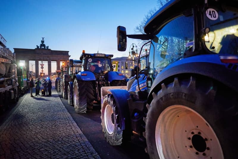 Numerous tractors stand in front of the Brandenburg Gate during a farmers' protest on the street 17. In response to the federal government's austerity plans, the farmers' association has called for a week of action with rallies on 8 January. Jörg Carstensen/dpa