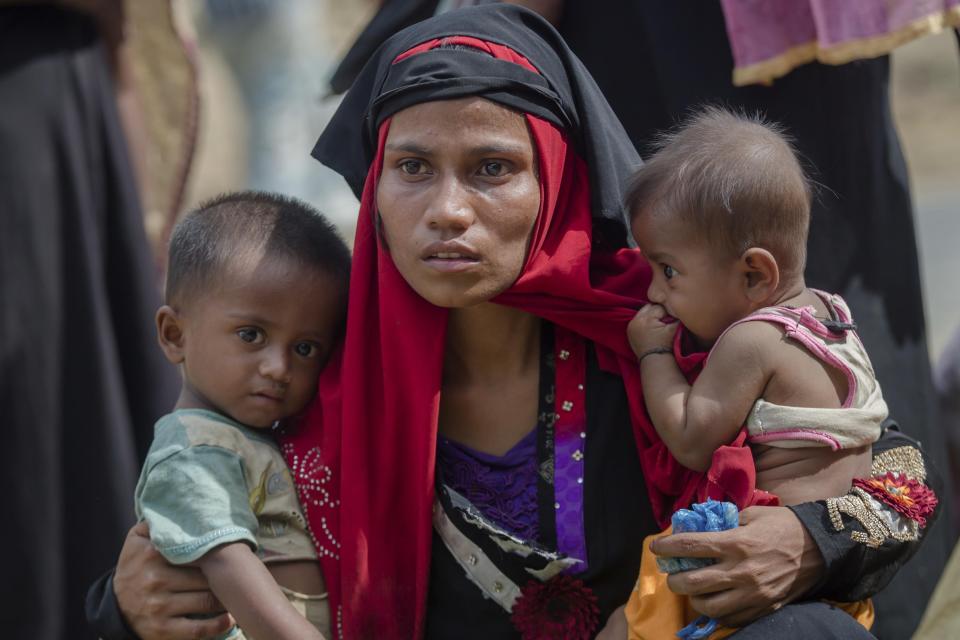 FILE - In this Oct. 22, 2017, file photo, a Rohingya Muslim woman, Rukaya Begum, who crossed over from Myanmar into Bangladesh, holds her son Mahbubur Rehman, left and her daughter Rehana Bibi, after the government moved them to newly allocated refugee camp areas, near Kutupalong, Bangladesh. Officials from the U.N. refugee agency and Bangladesh's government say few Muslim Rohingya refugees have responded to plans for their repatriation to Myanmar, and all who did say they don't want to go back. (AP Photo/Dar Yasin, File)