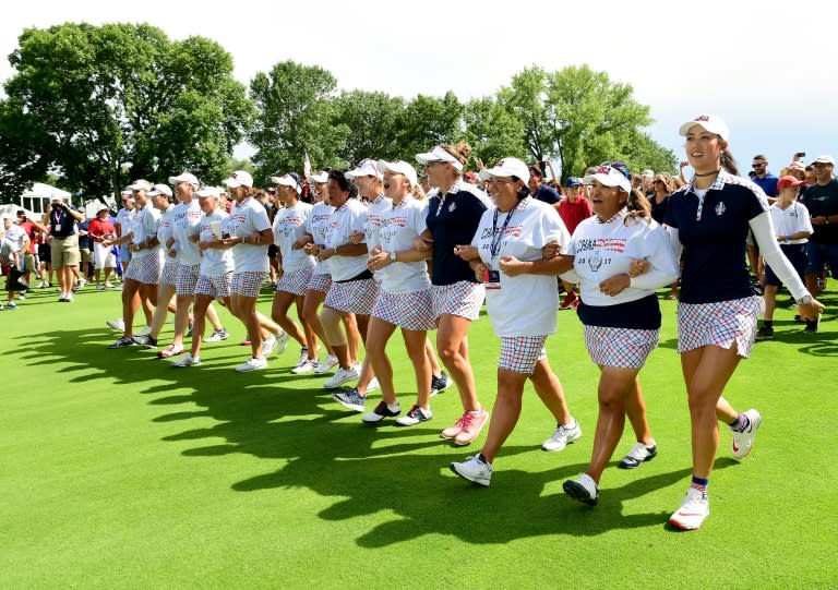 Team USA walk arm and arm up the 18th fairway after beating Team Europe in the Solheim Cup on August 20, 2017