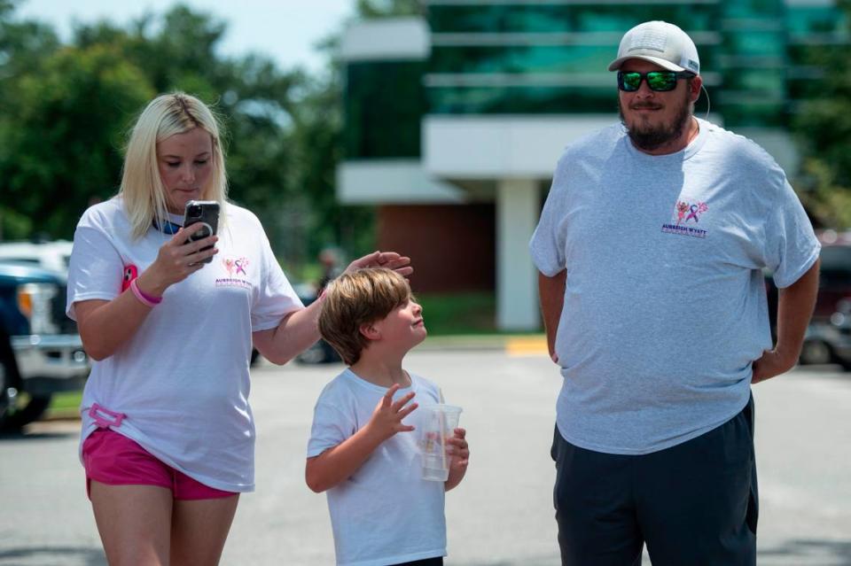 Heather Wyatt’s son Ryker, 7, waits outside the Jackson County courthouse in Pascagoula with his father Dexter Woods and his stepmother on Thursday, July 18, 2024. During the time Heather Wyatt was court ordered to stop using social media, Woods posted videos about the family.
