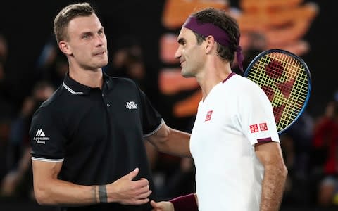 Switzerland's Roger Federer, right, is congratulated by Hungary's Marton Fucsovics after winning their fourth round singles match at the Australian Open tennis championship in Melbourne, Australia, Sunday, Jan. 26, 2020