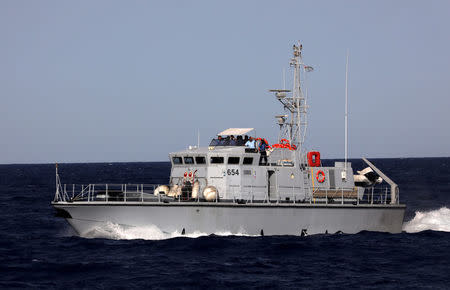 A Libyan coast guard vessel powers next to former fishing trawler Golf Azzurro of the Proactiva Open Arms rescue charity in the Western Mediterranean Sea August 15, 2017. REUTERS/Yannis Behrakis