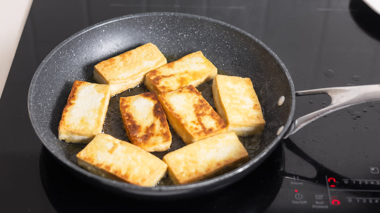 cooking tofu slices in skillet